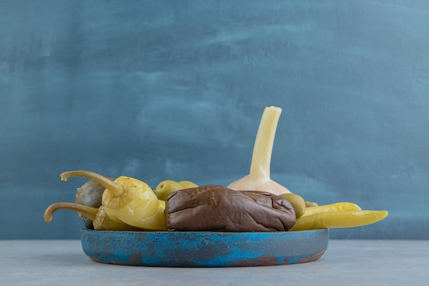 Bezpłatne zdjęcie marynowane ostrą papryką, oliwką, ogórkiem i bakłażanem na drewnianym talerzu