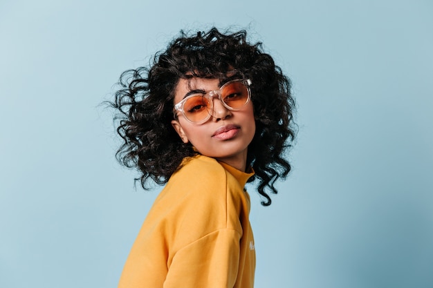 Bezpłatne zdjęcie marzycielska młoda kobieta patrząc z przodu w okularach przeciwsłonecznych