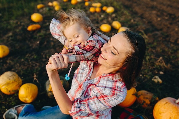 Matka bawi się z córką na polu z dyniami, wigilia Halloween