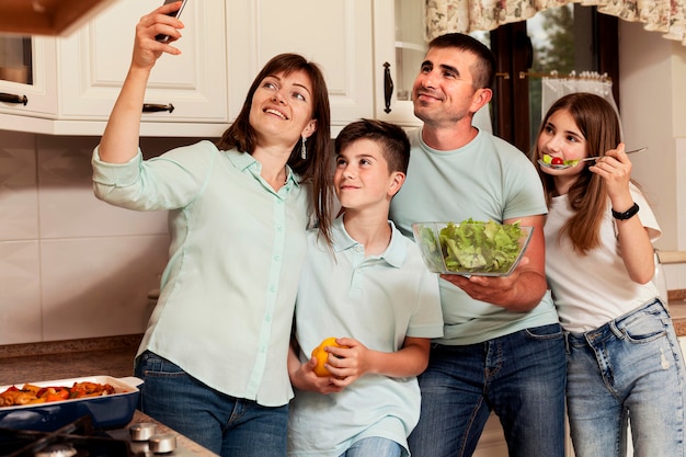 Matka biorąc selfie z rodziną w kuchni