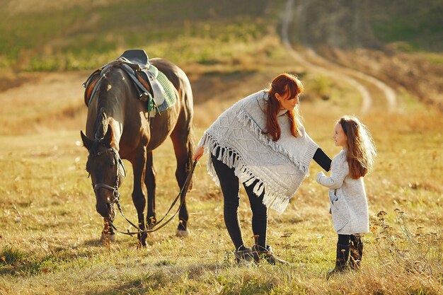Matka i córka w polu bawić się z koniem