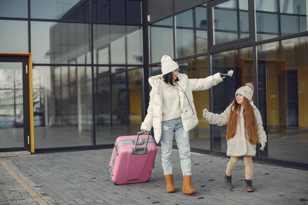 Matka i córka z bagażem wyjeżdżają z terminalu lotniska?