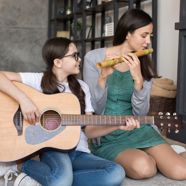 Bezpłatne zdjęcie matka i dziewczyna gra na instrumencie