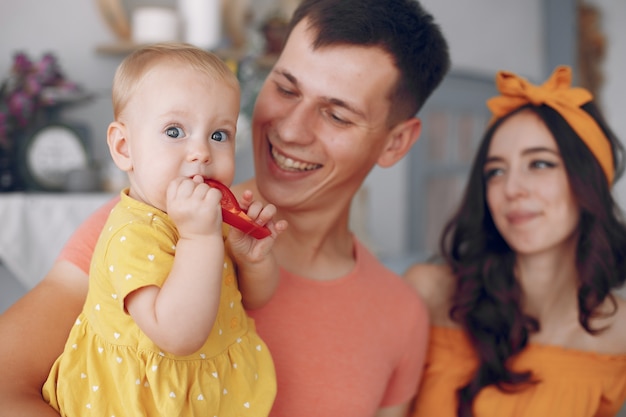 Bezpłatne zdjęcie matka i ojciec karmią córkę papryką