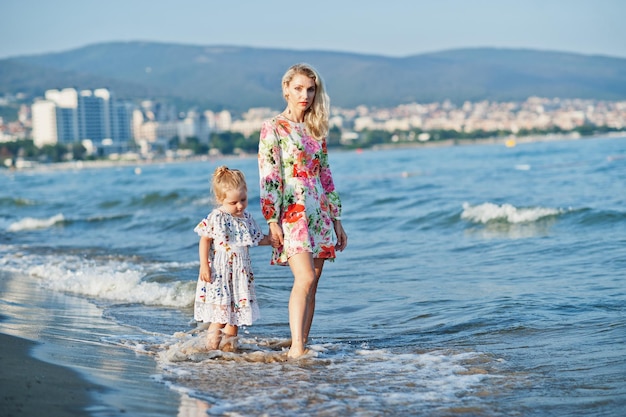 Matka i piękna córka bawią się na plaży Portret szczęśliwej kobiety z uroczą małą dziewczynką na wakacjach