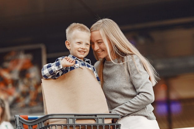 Matka Jedzie W Wózku. Rodzina Na Parkingu W Pobliżu Supermarketu.