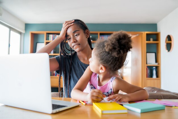 Matka pomaga córce i wspiera ją w szkole online podczas pobytu w domu. Nowa koncepcja normalnego stylu życia. Koncepcja monoparental.