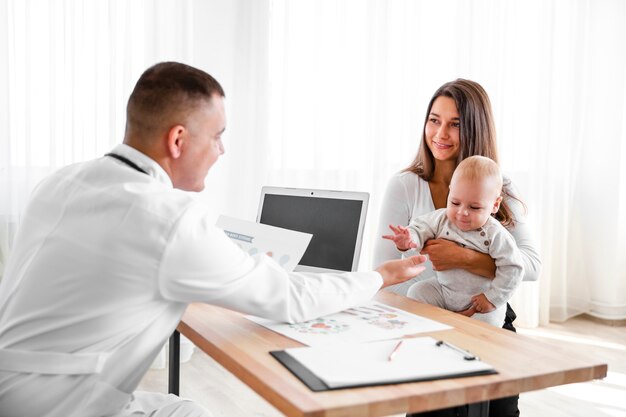 Matka trzyma małe dziecko i patrząc na lekarza