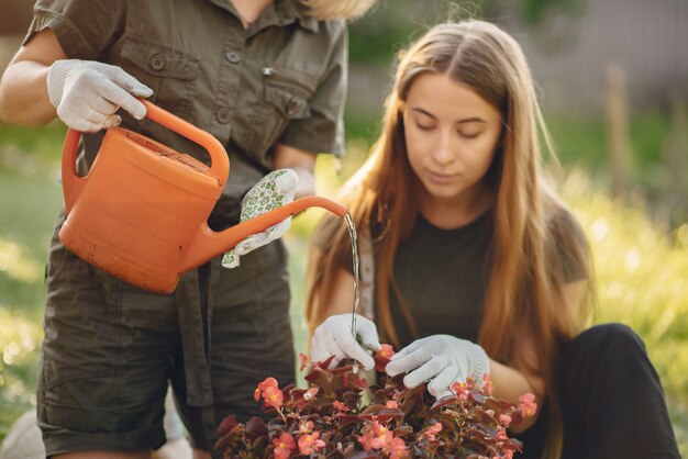 Matka z córką pracuje w ogrodzie niedaleko domu