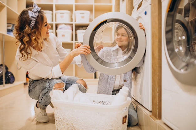 Matka z córką robi pranie w samoobsługowej pralni samoobsługowej