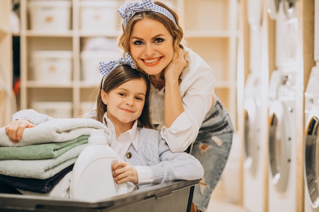 Bezpłatne zdjęcie matka z córką robi pranie w samoobsługowej pralni samoobsługowej