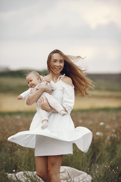 Matka z córką. Rodzina w polu. Nowo narodzona dziewczyna. Kobieta w białej sukni.
