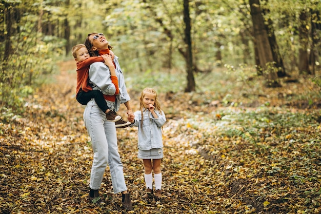 Matka z jej małym synem i córką w jesień parku