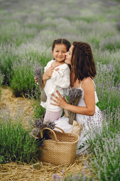 Matka z małą córeczką na lawendowym polu. Piękna kobieta i słodkie dziecko grając w pole łąka. Urlop rodzinny w letni dzień.