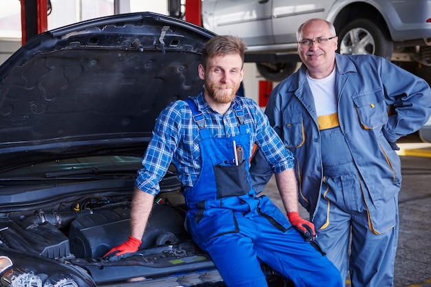 Mechanicy naprawiający samochód w warsztacie