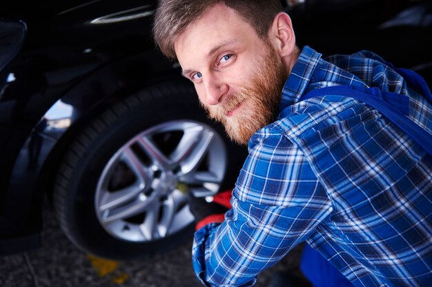 Mechanik naprawiający samochód w warsztacie