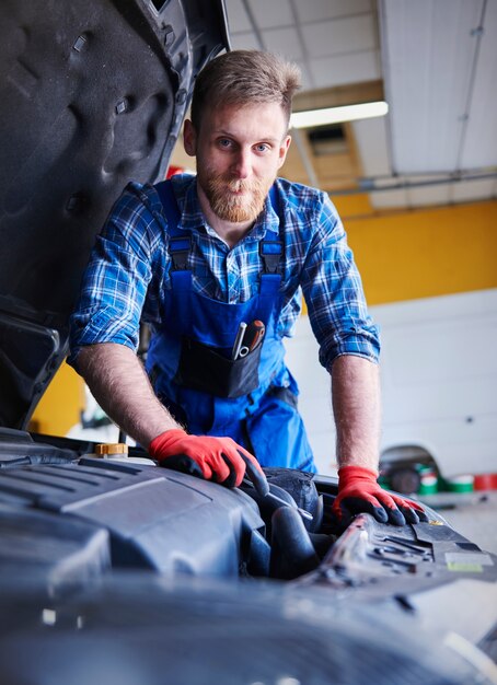 Mechanik naprawiający samochód w warsztacie