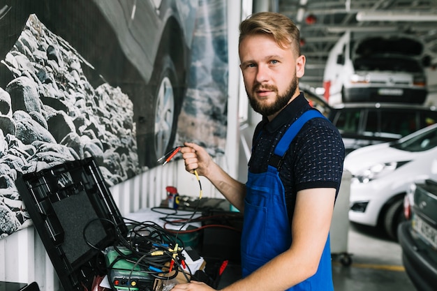 Bezpłatne zdjęcie mechanik pracuje z drutami przy warsztatem