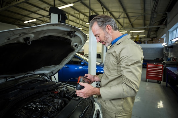 Bezpłatne zdjęcie mechanik przy pomocy przyrządu diagnostycznego