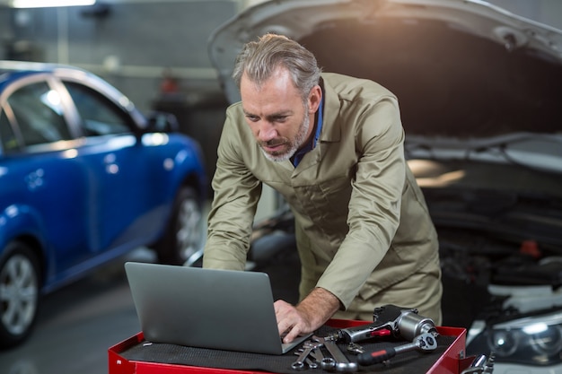 Bezpłatne zdjęcie mechanik za pomocą laptopa