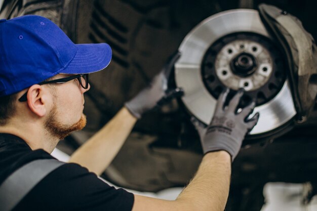 Mechanik zmieniający tarcze hamulcowe w serwisie samochodowym