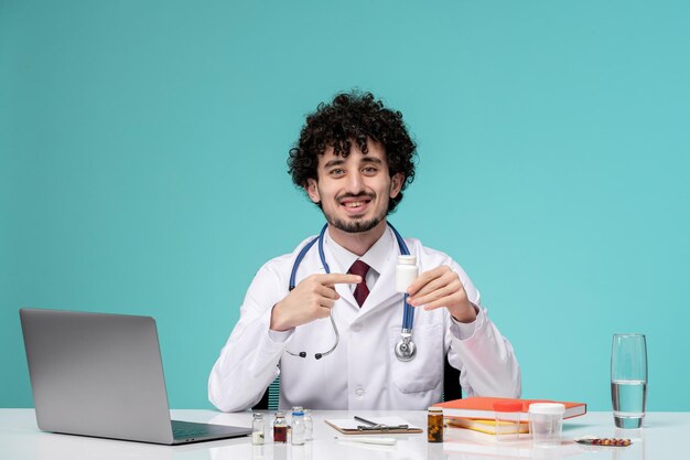 Medyczna praca na komputerze zdalnie poważny słodki inteligentny lekarz w fartuchu laboratoryjnym trzymającym pigułki