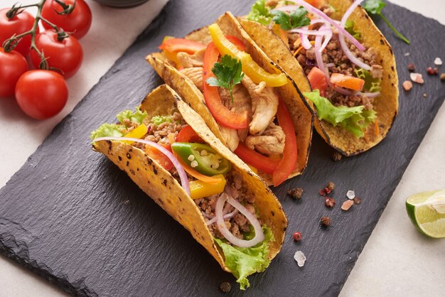 Meksykańskie tacos z mięsem, uliczne tacos wieprzowe carnitas w żółtej tortilli kukurydzianej z cebulą, kolendrą i kapustą. czerwona kapusta. Widok z góry. leżał płasko.