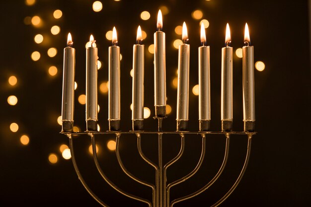 Menorah z świeczkami blisko abstrakcjonistycznych girland świateł