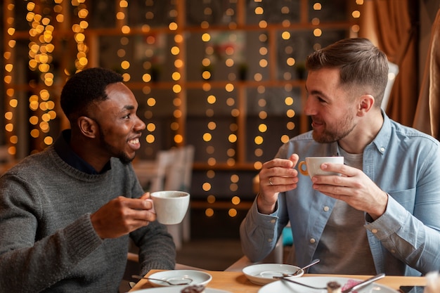 Męscy przyjaciele pije kawę przy restauracją
