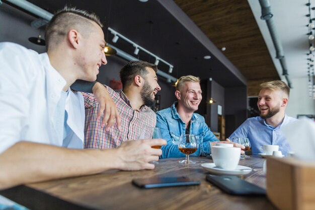 Męscy przyjaciele siedzi przy restauracją