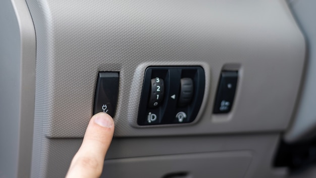 Bezpłatne zdjęcie męska ręka naciskająca przycisk w samochodzie elektrycznym