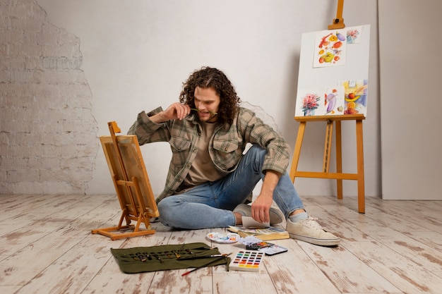 Męski artysta malujący w studio z akwarelami