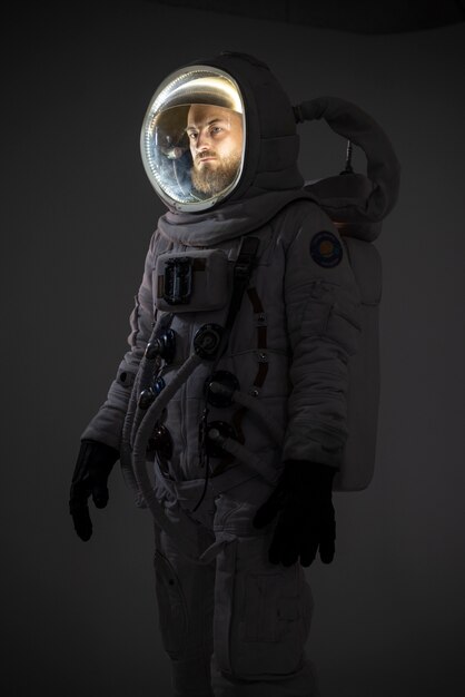Męski astronauta w pełni wyposażony w skafander kosmiczny i kask