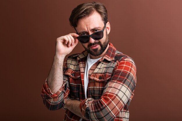 Męski hipster przystojny stylowy brodaty mężczyzna na brązowym