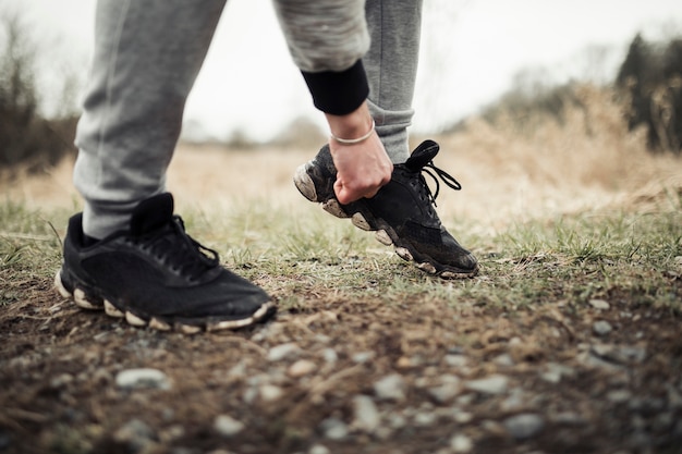 Męski jogger stoi na śladzie przystosowywa jego but