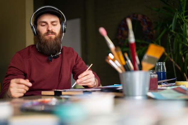 Męski malarz w studiu używający akwareli na swojej sztuce