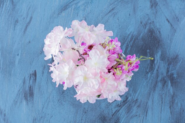 Metalowe wiadro pełne pięknych kolorowych kwiatów na niebiesko.