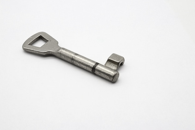 Bezpłatne zdjęcie metalowy klucz umieszczony na przezroczystej białej powierzchni