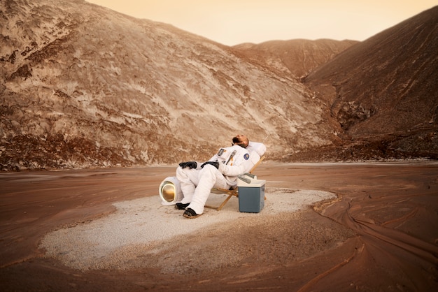 Bezpłatne zdjęcie mężczyzna astronauta odpoczywa na nieznanej planecie