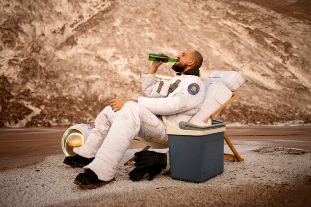 Mężczyzna astronauta pijący piwo podczas misji kosmicznej na nieznanej planecie