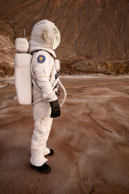 Mężczyzna astronauta rozglądający się podczas misji kosmicznej na innej planecie