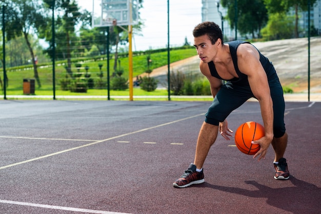 Mężczyzna bawić się koszykówkę na parkowym sądzie