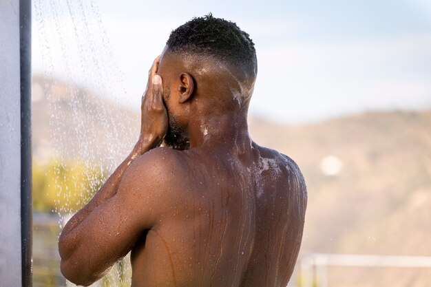 Mężczyzna biorący prysznic portretowy widok z boku