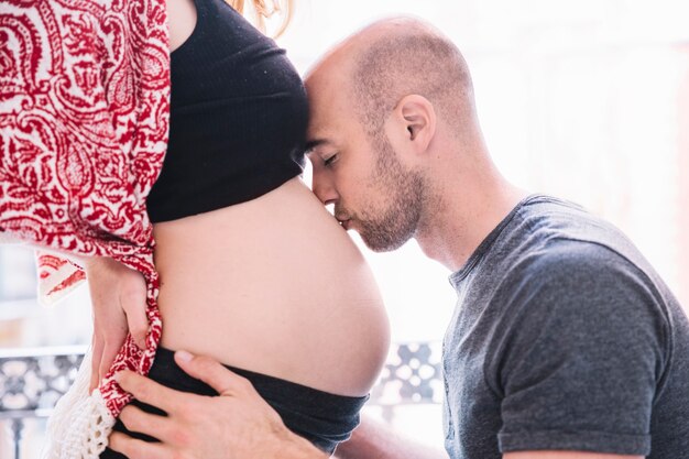Mężczyzna całuje kobiety w ciąży