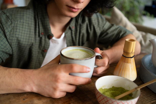 Mężczyzna cieszy się filiżanką herbaty matcha