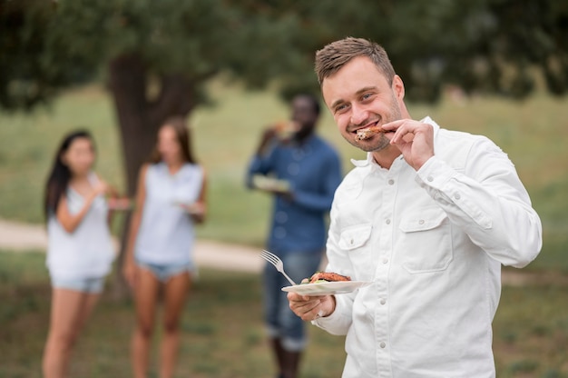 Bezpłatne zdjęcie mężczyzna cieszy się jedzeniem przy grillu