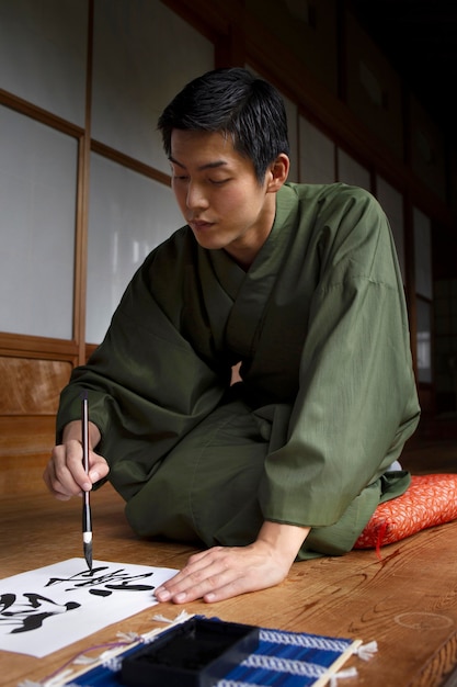Mężczyzna ćwiczący japońskie pismo odręczne