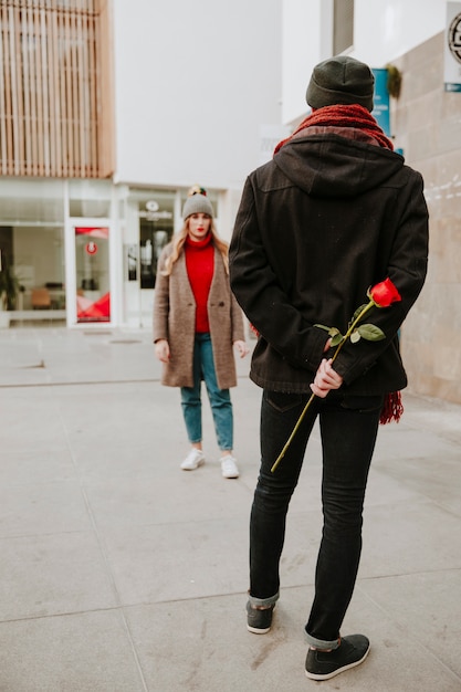 Mężczyzna czeka dziewczynę z różą