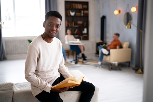 Mężczyzna czyta książkę w klubie czytelniczym lub bibliotece