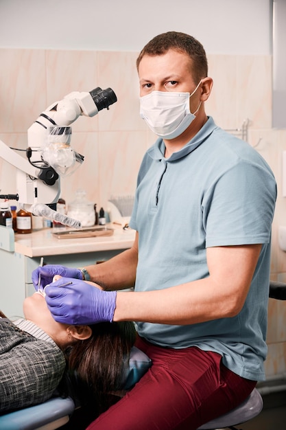 Mężczyzna Dentysta Badający Zęby Pacjenta W Gabinecie Stomatologicznym